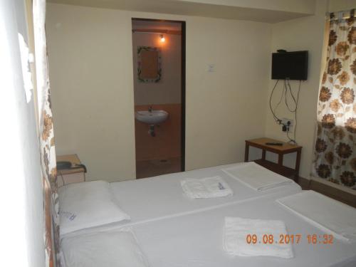 a bedroom with a bed and a sink in it at HOTEL RUKMINI in Vasco Da Gama