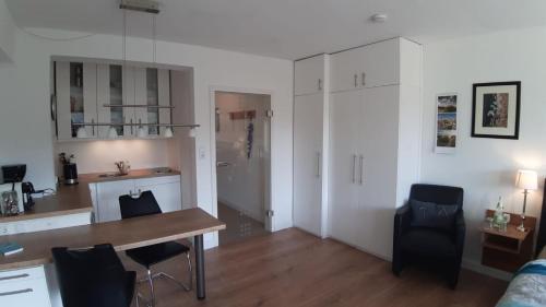 eine Küche und ein Esszimmer mit einem Tisch und Stühlen in der Unterkunft Modern City Apartment with balcony and nice parc view in Bremen