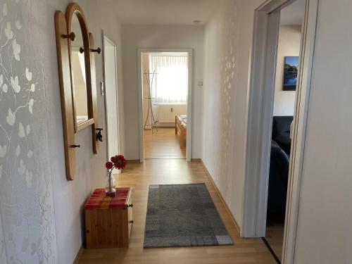 a hallway with a mirror and a vase on a table at Fewo Haus Piepenbreier in Bad Sassendorf