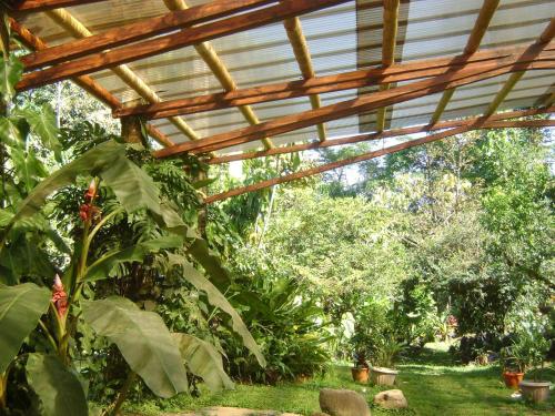 a wooden pergola in a garden with plants at Cascata Del Bosco Cabinas in San Vito