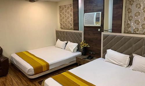 two beds in a small room with two beds sidx sidx sidx at Shila International in Kolkata