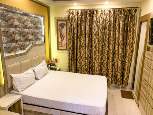 a bedroom with a white bed and a window at Shila International in Kolkata