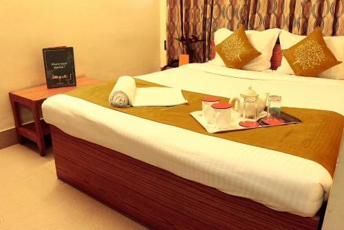 a hotel room with a tray of food on a bed at Shila International in Kolkata