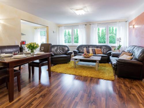 a living room with leather furniture and a table at Gorgeous Apartment in Markdorf with Swimming Pool in Markdorf