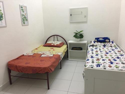 two twin beds in a room with at D Wangi Homestay Pasir Gudang at Ecotropic in Pasir Gudang