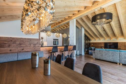 a dining room with a table and chairs and a chandelier at Hotel Hemizeus & Iremia Spa in Zermatt