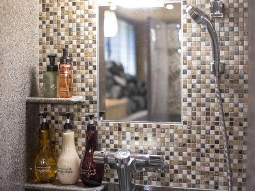 a bathroom sink with a mirror and a shower at Onyado Nono Kyoto Shichijo Natural Hot Spring in Kyoto