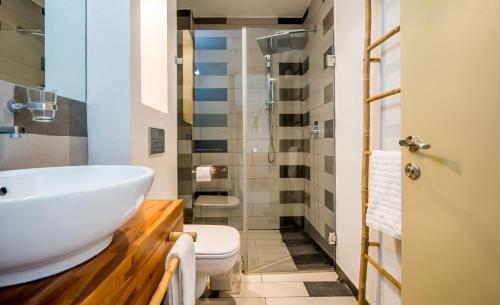 a bathroom with a white sink and a toilet at Bat Galim Boutique Hotel in Haifa