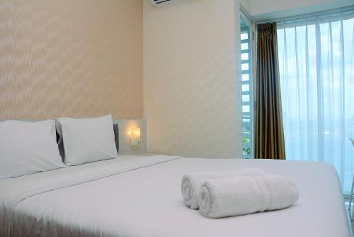Ένα ή περισσότερα κρεβάτια σε δωμάτιο στο Comfy with Modern Style 1BR Grand Kamala Lagoon Apartment By Travelio