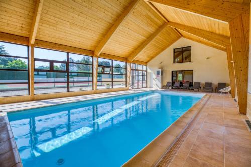 - une piscine dans une maison dotée d'un plafond en bois dans l'établissement Maison confortable avec piscine à Villentrois-Faverolles 250m², à Faverolles