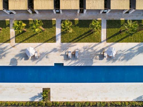 an overhead view of a pool with tables and umbrellas at Il San Corrado di Noto in Noto