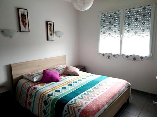 a bedroom with a bed with two pillows on it at Maison familiale avec jardin à Lit-et-Mixe, 100 m² in Lit-et-Mixe