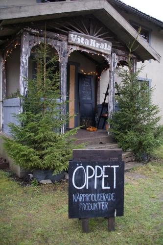 a sign in front of a house with two christmas trees at Vita Krala in Haddebo