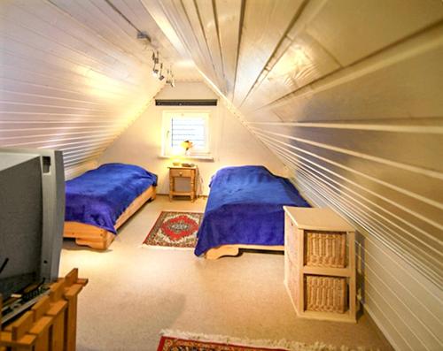a bedroom with two beds and a tv in a room at Modern Apartment Westerland 50m² + Garden in Westerland (Sylt)