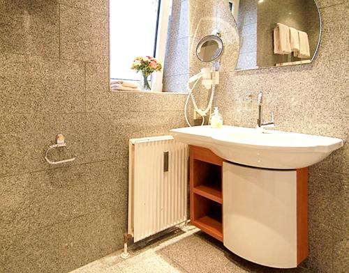a bathroom with a sink and a mirror at Modern Apartment Westerland 50m² + Garden in Westerland (Sylt)
