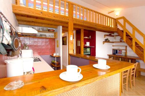 - une cuisine avec un comptoir en bois et 2 tasses dans l'établissement Appartement charmant avec piscine à Porticcio - 32 m², à Porticcio