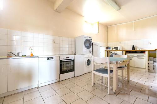 una cocina con electrodomésticos blancos y una mesa. en Maison de 4 chambres avec jardin amenage et wifi a Monthenault en Monthenault