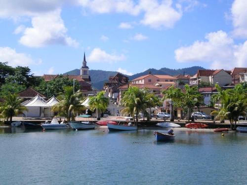 a group of boats on the water in a town at Appartement accueillant avec vue sur la mer - 70 m² à Les Trois-Îlets in Les Trois-Îlets