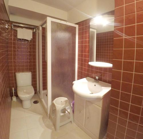 y baño con aseo, lavabo y ducha. en One bedroom appartement with furnished terrace and wifi at Llanes 3 km away from the beach, en Llanes