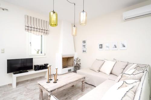a white living room with a white couch and a tv at Spacious Villa in Naxos with Sea View in Naxos Chora