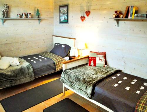 a bedroom with two beds and a bench in it at Appartement spacieux à Xonrupt-Longemer + Sauna in Xonrupt-Longemer