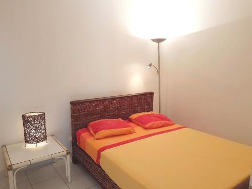 a bedroom with a bed with two pillows and a lamp at Maison d'une chambre avec vue sur la mer jardin amenage et wifi a Alata a 8 km de la plage in Alata