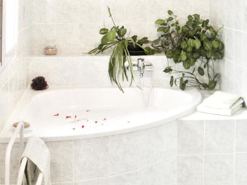 a white bathroom with a bath tub with a plant at Maison d'une chambre avec vue sur la mer jardin amenage et wifi a Alata a 8 km de la plage in Alata
