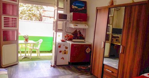 a kitchen with a red and white refrigerator and a table at Studio a Fort de France a 500 m de la plage avec balcon amenage et wifi in Fort-de-France