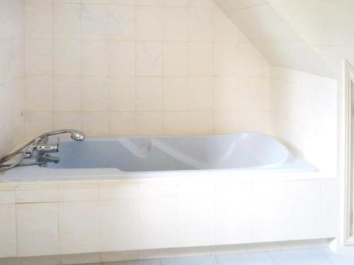 La salle de bains est pourvue d'une baignoire et de carrelage blanc. dans l'établissement Villa de charme à La Gaude avec piscine privée, à La Gaude