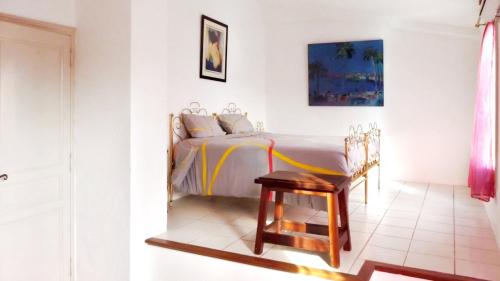 - une chambre avec un lit et un fauteuil en bois dans l'établissement Villa de charme à La Gaude avec piscine privée, à La Gaude