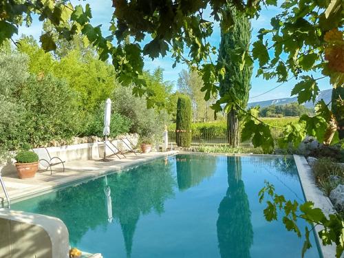 a swimming pool with blue water in a yard at Maison charmante à Oppède avec piscine partagée in Oppède