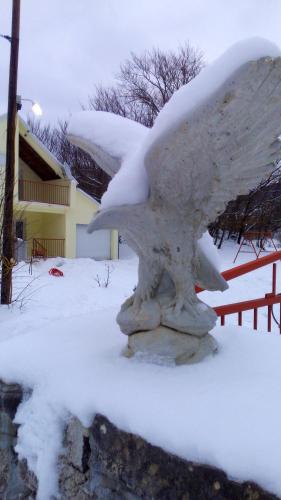 a statue covered in snow in front of a house at Charming chalet in Herceg Novi with fenced garden in Herceg-Novi