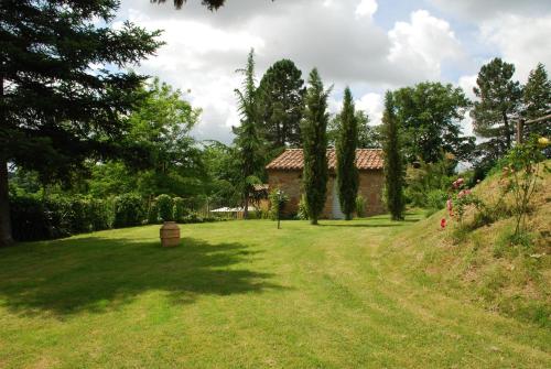 a yard with a house in the background with trees at Il Sentiero in Acquapendente
