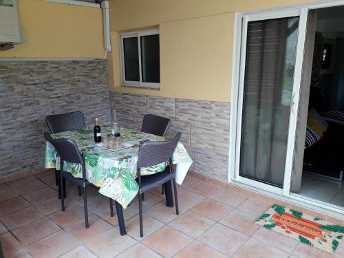Saint-JosephにあるAppartement charmant à Saint-Joseph avec jardin et terrasse, 60 m²のパティオ(テーブル、椅子付)