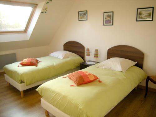 two beds sitting in a room with a window at Maison de 4 chambres a Plougrescant a 400 m de la plage avec vue sur la mer jardin clos et wifi in Plougrescant