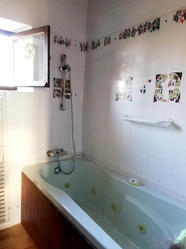 La salle de bains est pourvue d'une baignoire verte. dans l'établissement Maison spacieuse à St Constant Fournoules avec jardin, à Saint-Constant