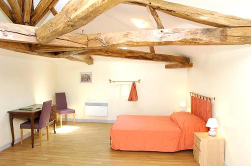 ein Schlafzimmer mit einem Bett und einem Schreibtisch in einem Zimmer in der Unterkunft Maison de 4 chambres avec piscine partagee jardin amenage et wifi a Saint Vincent la Chatre in Saint-Vincent-la-Châtre