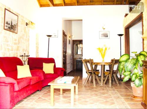 a living room with a red couch and a table at 2 bedrooms house at Hermigua 600 m away from the beach with sea view furnished balcony and wifi in Hermigua