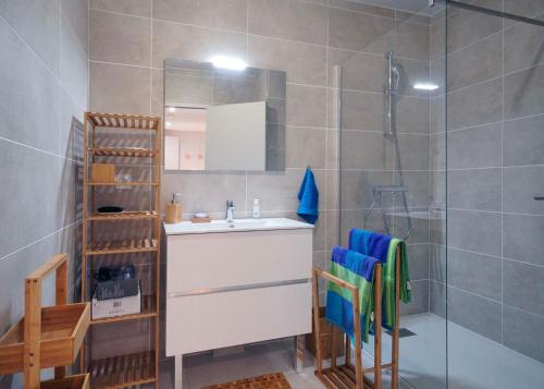 une salle de bain avec un lavabo et une douche avec un miroir dans l'établissement Appartement Complet pour 2 personnes Classé 4 étoiles - Au coeur des Golfs, à Saint-Raphaël