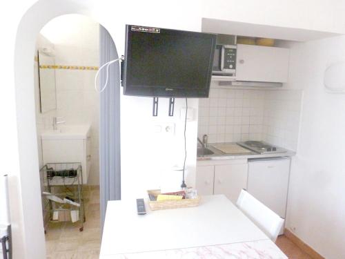 - une cuisine avec une télévision au-dessus d'un comptoir dans l'établissement Studio charmant à Pierrefeu-du-Var, 20 m², piscine partagée, à Pierrefeu-du-Var