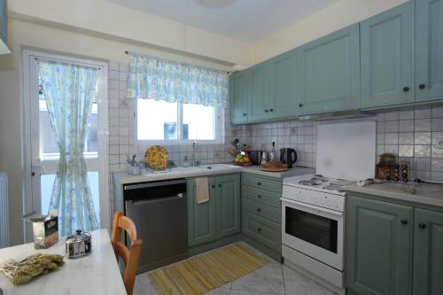 a kitchen with blue cabinets and a sink and a stove at Unique Flat with Sea View at Edem Beach - A Seafront Property by Athenian Homes in Athens