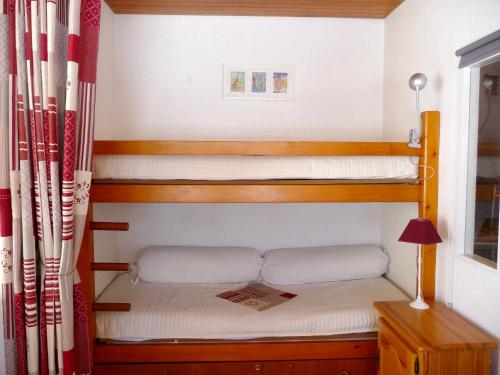 シャンルッスにあるAppartement d'une chambre avec balcon amenage a Chamrousseのベッドルーム1室(二段ベッド2組、ランプ付)
