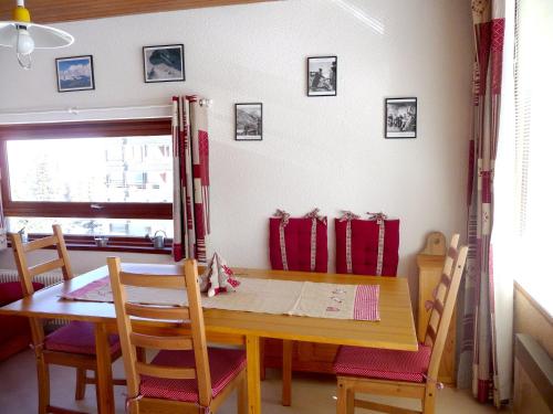 a dining room with a wooden table and chairs at Appartement d'une chambre avec balcon amenage a Chamrousse in Chamrousse