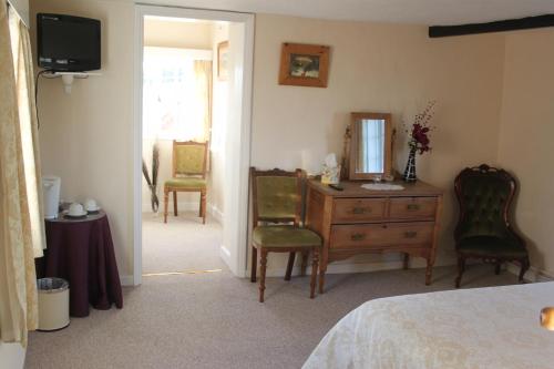 a bedroom with a desk and chairs and a mirror at Ingon Bank Farm Bed And Breakfast in Stratford-upon-Avon