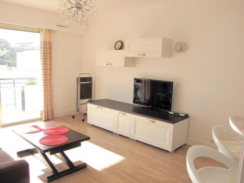 a living room with a flat screen tv and a table at Appartement moderne à Antibes - 50 m² - Vue sur jardin in Antibes