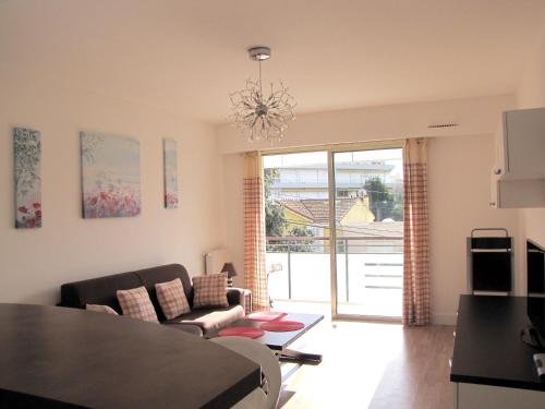 a living room with a couch and a table at Appartement moderne à Antibes - 50 m² - Vue sur jardin in Antibes