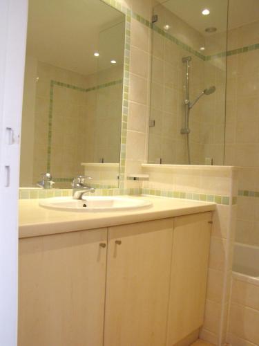 une salle de bain avec un lavabo et un miroir dans l'établissement Appartement moderne à Antibes - 50 m² - Vue sur jardin, à Antibes