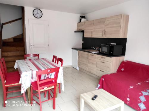 eine Küche und ein Wohnzimmer mit einem Tisch und einem Sofa in der Unterkunft Maison d'une chambre avec terrasse amenagee et wifi a Solesmes in Solesmes