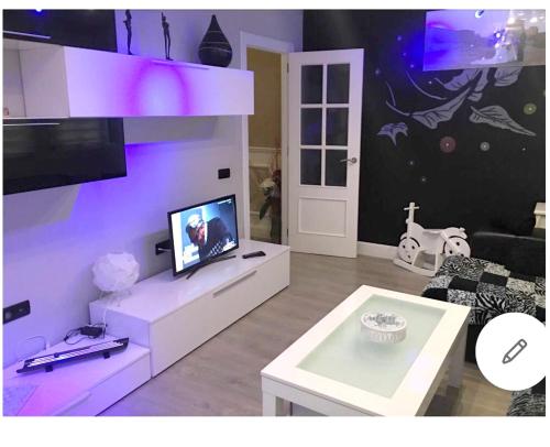 a living room with a tv and a table at Modern apartment with jacuzzi and city view, Almería, 80 m² in Almería