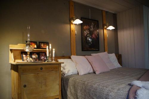 a bedroom with a bed and a dresser with candles at Vita Krala in Haddebo